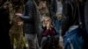 A woman reacts as she waits for a train trying to leave Kyiv, Feb. 24, 2022, as Russia launched its invasion of Ukraine.