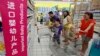 FILE - A family looks at foreign imported milk powder products at a supermarket in Beijing, July 3, 2013.