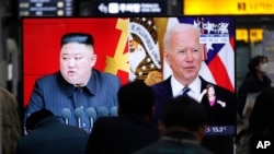 FILE - Commuters watch a TV sreen showing images of North Korean leader Kim Jong Un and U.S. President Joe Biden during a news broadcast at the Suseo Railway Station in Seoul, South Korea, March 26, 2021.