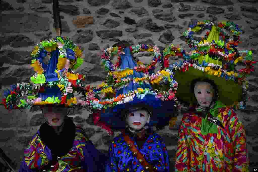 A group of participants dressed in traditional clothes and wearing large hats decorated with ribbons and feathers, known as ''Ttutturo'', take part in the Carnival of the Pyrenees villages of Leitza, northern Spain, Jan. 30, 2018.