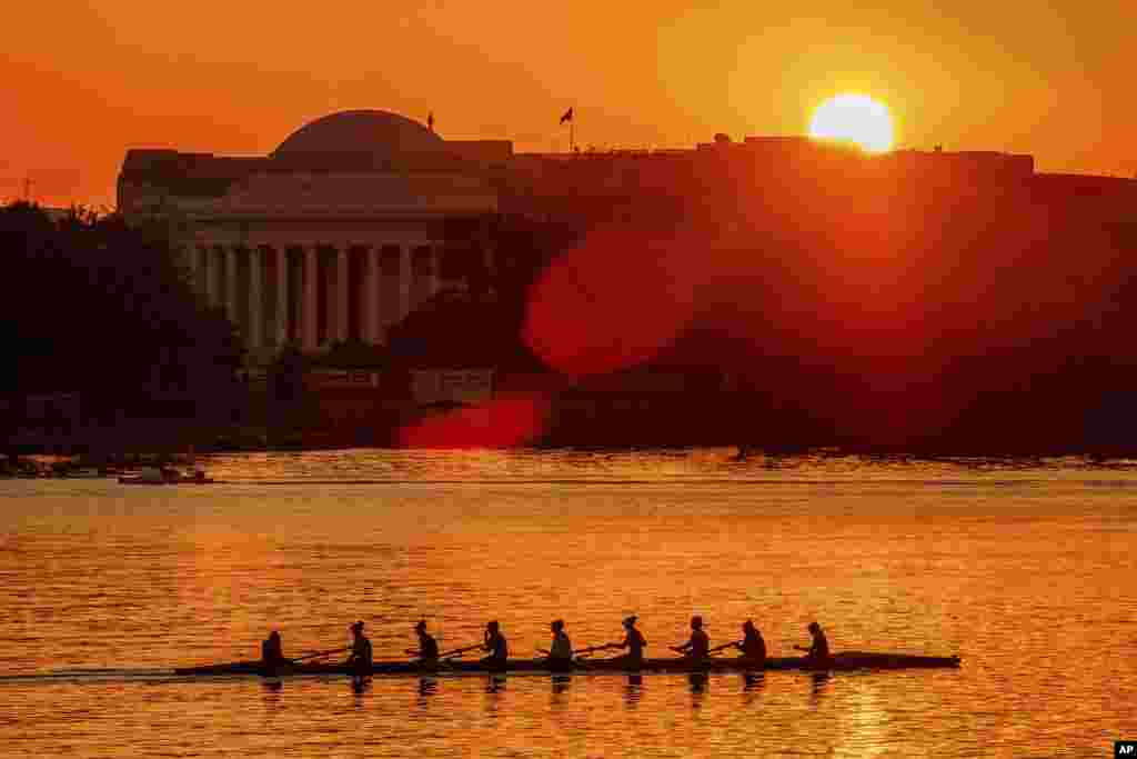 Rowers skim along the Potomac River as the sun rises over the Jefferson Memorial in Washington.
