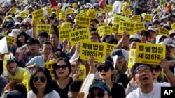 FILE - South Koreans shout slogans during a rally demanding the adoption of a special law for the sunken ferry Sewol in Seoul, South Korea, Friday, Aug. 15, 2014.