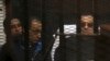 FILE - Ousted Egyptian President Hosni Mubarak, 86, next to his son Gamal, second left, in the defendants cage, during a court hearing in Cairo, Egypt.
