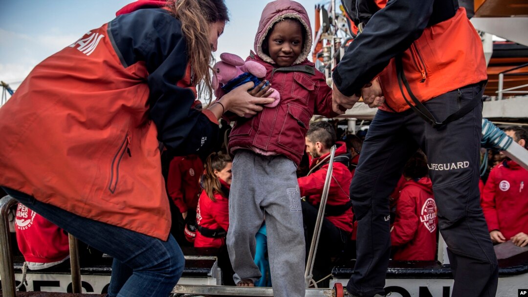 A migrant child is helped from the Spanish NGO Proactiva Open Arms rescue vessel, after being rescued Dec. 21, in the Central Mediterranean Sea, to disembark in the port of Crinavis in Algeciras, Spain, Dec. 28, 2018.