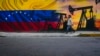 FILE - A man walks past a mural featuring oil pumps and wells in Caracas, Venezuela, May 21, 2022. 