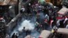 An anti-government protester prepares to throw a tear gas canister fired by Iraq security forces to disperse a crowd during a demonstration, in Baghdad, Iraq, Oct. 30, 2019. 