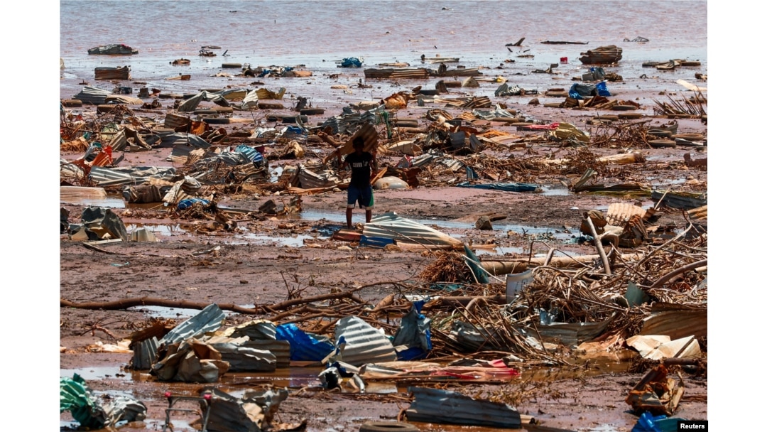 Dečak nosi deo srušenog krova na plaži na ostrvu Majot (Foto: Reuters/Gonzalo Fuentes)