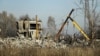 Workers clean rubbles after a Ukrainian rocket strike in Makiivka, in Russian-controlled Donetsk region, eastern Ukraine, Tuesday, Jan. 3, 2023.