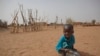 FILE - А boy is seen eating dry couscous in the village of Goudoude Diobe, in the Matam region of northeastern Senegal.