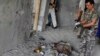 An Afghan security officer stands near the body of an insurgent killed in a battle near Kabul airport, Afghanistan, June, 10, 2013. 