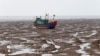 A fishing boat is seen during the low tide at the beach in Thanh Hoa province, Vietnam June 4, 2018.