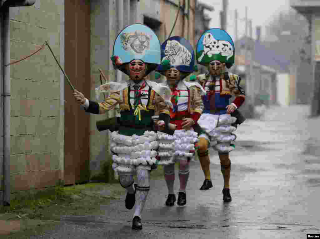 Carnival revelers dressed as "Peliqueiros" run along a street in the village of Laza, Spain.
