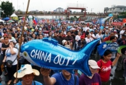 Protesters display a balloon with an anti-China message during a rally near the Philippine Congress to protest the 4th State of the Nation (SONA) address by President Rodrigo Duterte, July 22, 2019, in suburban Quezon city, Philippines.