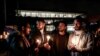 Demonstrators hold candles during a gathering in front of the Acropolis museum at the foot of the Acropolis hill in Athens, Sunday Jan. 18, 2015.