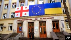 Прапори Грузії, ЄС і України висять на виборчій дільниці під час парламентських виборів у Тбілісі, Грузія, у суботу, 26 жовтня 2024 р. (AP Photo/Shakh Aivazov)