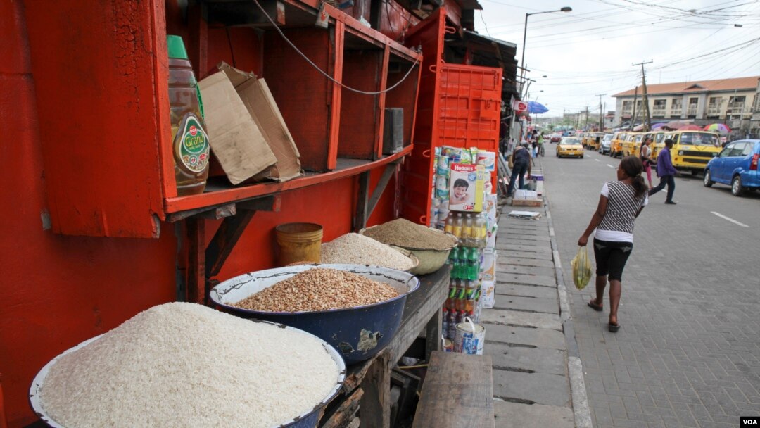Local and imported rice is sold from bowls in front of a shop in Obalende market in Lagos, Nigeria, March 3, 2016. (C. Stein/VOA)