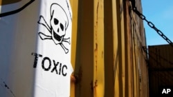 FILE - A sticker reads "Toxic" is seen on containers carrying Syria's dangerous chemical weapons, on the Danish cargo ship, Ark Futura, transporting them out of the strife-torn country, in Cyprus coastal waters, May 13, 2014.