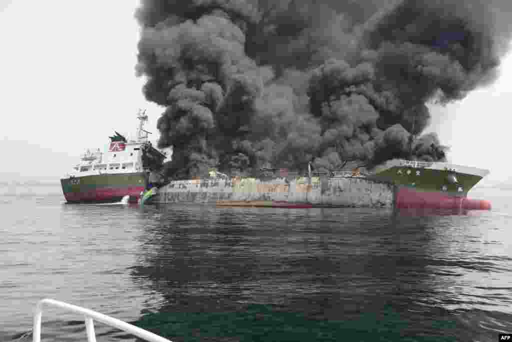 This handout picture taken and released by Japan&#39;s Coast Guard shows black smoke rising from a 998-ton oil tanker off the coast of Hyogo prefecture, around 450 kilometers (280 miles) west of Tokyo.