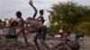 In this photo taken Thursday, June 5, 2014, displaced children wash themselves on the muddy bank of a river just outside the United Nations base which has become home to thousands of those displaced by recent fighting, in the town of Malakal, Upper Nile S