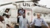 A member of the joint U.N. African Union Mission in Darfur (UNAMID), right, escorts three freed humanitarian workers out of a U.N. helicopter as they landed in El Fasher, North Darfur, Sudan, Saturday, July 19, 2014. The international peacekeeping mission