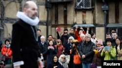 Tourists watch actors perform at the house where William Shakespeare was born during celebrations to mark the 400th anniversary of the playwright's death in Stratford-Upon-Avon, England, April 23, 2016.