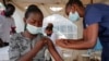 A nurse administers an AstraZeneca vaccination against COVID-19, at a district health center giving first, second, and booster doses to eligible people, in the low-income Kibera neighborhood of Nairobi, Kenya, Jan. 20, 2022. 
