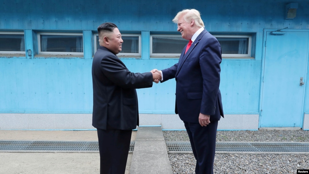 FILE - Then-U.S. President Donald Trump shakes hands with North Korean leader Kim Jong Un as they meet at the demilitarized zone separating the two Koreas, in Panmunjom, South Korea, June 30, 2019.