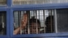 A man flashes the three-finger salute after being arrested during a protest against the military coup in Mawlamyine, Myanmar, Feb. 12, 2021. (Than Lwin Times/Handout via Reuters)
