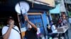 Los voluntarios utilizan un megáfono cerca de un centro de votación en el barrio de bajos ingresos de La Cruz en Caracas, durante la consulta popular convocada por la oposición. [Foto: Reuters]