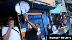 Los voluntarios utilizan un megáfono cerca de un centro de votación en el barrio de bajos ingresos de La Cruz en Caracas, durante la consulta popular convocada por la oposición. [Foto: Reuters]