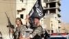 Fighters with the militant group Islamic State in Iraq and the Levant (ISIL, also called ISIS by some) wave flags as they take part in a military parade along the streets of Raqqa province, northern Syria, June 30, 2014. 