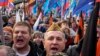 Демонстранти з державними прапорами та радянською військовою символікою біля Кремля. AP Photo/Alexander Zemlianichenko
