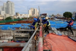 FILE - Workers lay out steel bars in constructing the 8-kilometer, four-lane elevated highway along Buendia Avenue in Makati City, metro Manila, Philippines, Aug. 3, 2017.