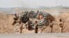 Volunteers with Kurdish peshmerga forces clash with Islamic State militants in the town of Daquq, south of Kirkuk, Sept. 30, 2014. 