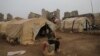 FILE - Abeer abo Almajed, 10, sits in front of her family's tent in Babisqa, in the northern countryside of Idlib, Syria, Nov. 29, 2021.