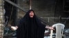 A woman reacts at the site of a car bomb attack that killed a parliament member and 24 others Tuesday, at the entrance to the Shi'ite neighborhood of Kadhimiya in Baghdad, Oct. 15, 2014. 