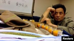 El pariente de una de las víctimas del vuelo de Malaysian Airlines, ora en el hotel Lido en Beijin.