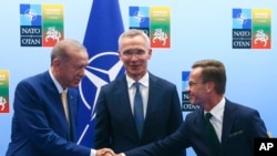 Presidenti turk Recep Tayyip Erdogan duke shtrënguar duart me kryeminstrin suedez Ulf Kristersson, në prani të Sekretarit të Përgjithshëm të NATO-s, Jens Stoltenberg, në takimin e nivelit të lartë të NATO-s, në Vilnius të Lituanisë, 10 korrik, 2023,