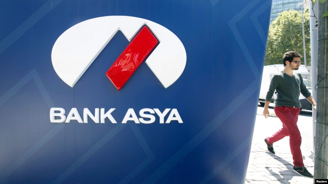 FILE - A man walks past an ATM machine of Bank Asya in Istanbul, Turkey, Aug. 12, 2014.
