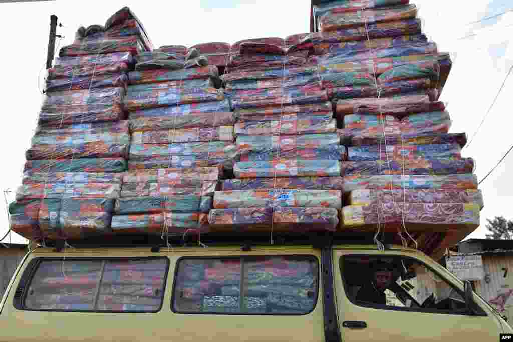 A man transports a pile of mattresse on the roof of a mini van at Ng&#39;ando slum in the Kenyan capital, Nairobi, Jan. 16, 2018.