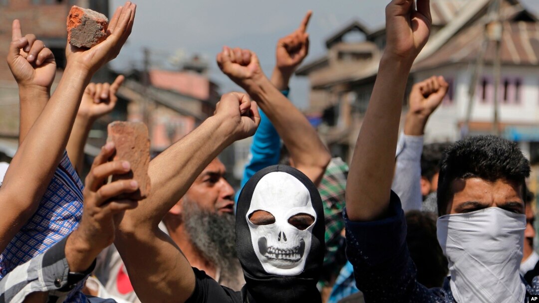 Masked Kashmiri protesters hold bricks as they shout freedom slogans in Srinagar, India, May. 27, 2017. One civilian was killed and dozens of others injured Saturday after massive anti-India protests and clashes erupted in Indian-controlled Kashmir following the killing of a prominent rebel commander and his associate.