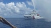 FILE - A Chinese Coast Guard boat approaches a Filipino fishing vessel off Scarborough Shoal in the South China Sea, Sept. 23, 2015.