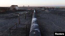 FILE - Damaged tanks and pipelines are seen at the oil port of Ras Lanuf, Libya January 11, 2017.