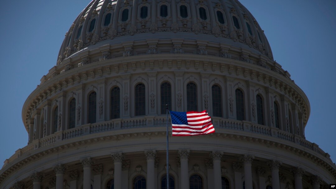 FILE - An American flag is seen flying in front of the dome of the United States Capitol building, July 26, 2011.