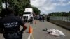 A Central American migrant, who fell from the back of a moving vehicle and died, lies on a highway covered by a sheet outside of Tapachula, Mexico, Oct. 22, 2018.