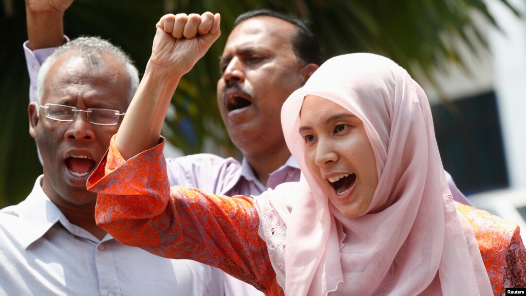 FILE - Nurul Izzah Anwar, right, daughter of imprisoned Malaysian opposition leader Anwar Ibrahim, leads a chant in Kuala Lumpur, March 17, 2015. 