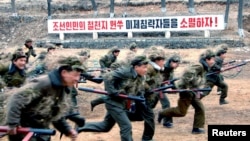 북한 조선중앙통신이 지난 13일 공개한 노동적위대원들의 군사훈련 장면. 미국에 대한 적대 구호가 세겨져 있다.