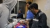 FILE - A paramedic treats an injured woman wounded by Israeli missile strikes at a hospital in Damascus, Syria, Nov. 20, 2019.