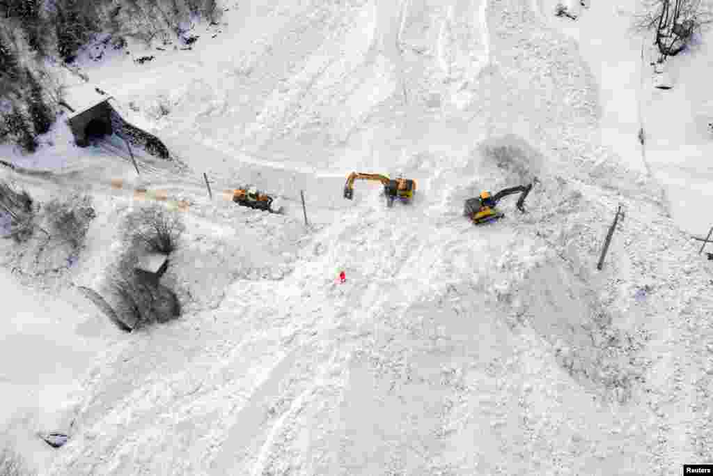 Excavators remove the snow on the site of an avalanche that covered the railway of the Brig Visp Zermatt Bahn company between Visp and Taesch 8 near Sankt Niklaus, Swiss Alps.