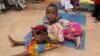A girl rescued from the Sambisa forest cradles another girl in her lap at a displaced persons camp in Malkohi, Nigeria on May 5, 2015. (Chris Stein/VOA)